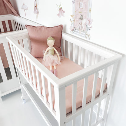 Bedside bassinet with front rail up and shelf underneath