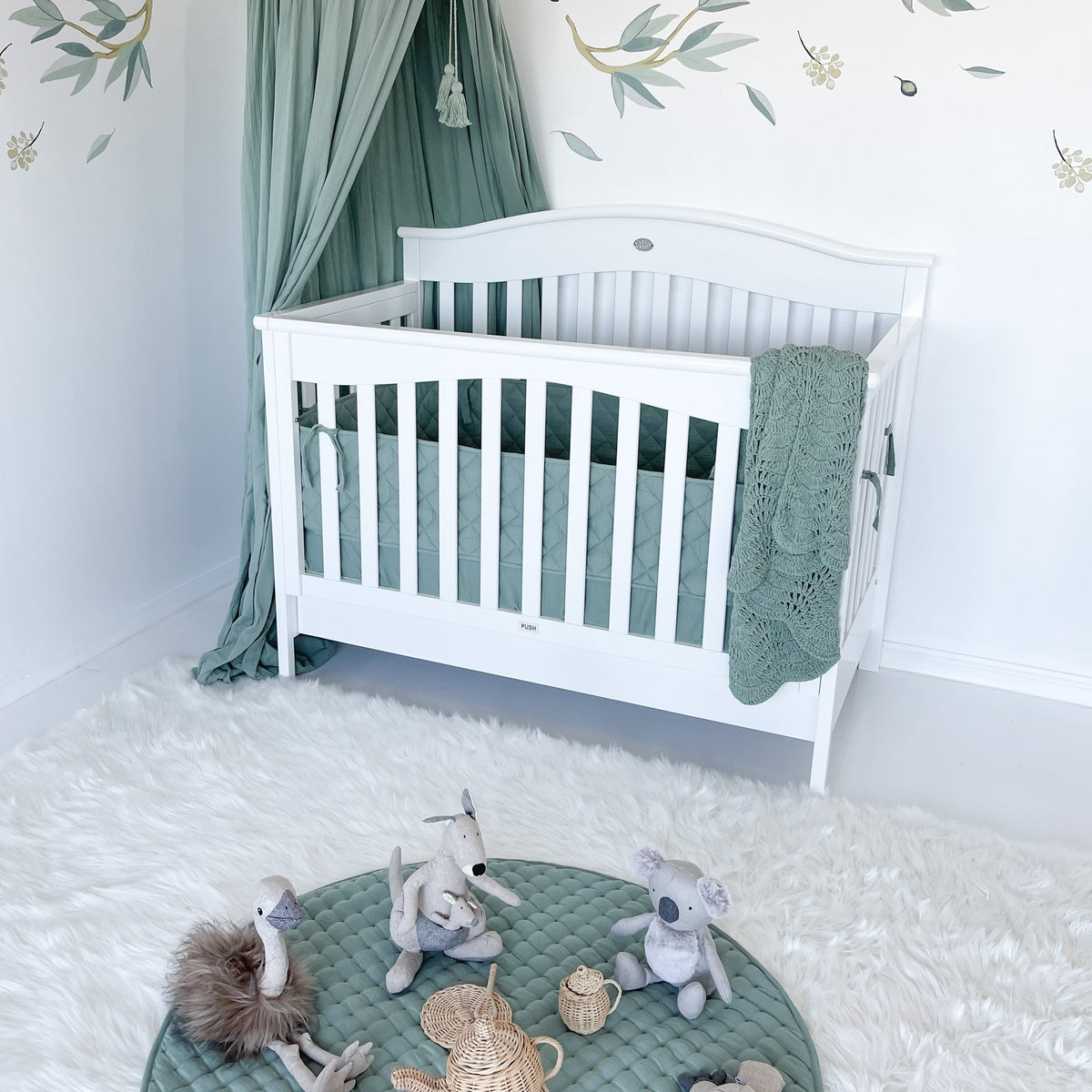 Side view of Heritage cot with bed base lowered